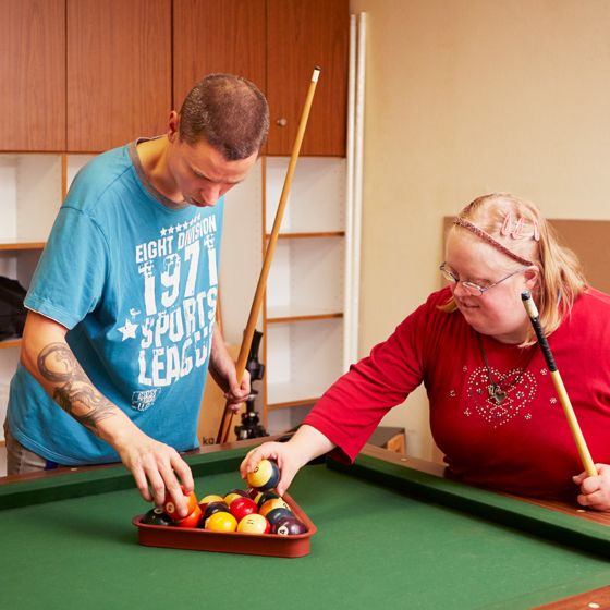 Ein Bewohner und eine Bewohnerin spielen Billiard Ein Bewohner und eine Bewohnerin spielen Billiard